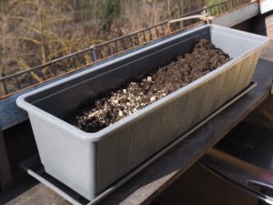 Orto sul balcone con piante fresche e fiori, ideale per il raccolto di marzo.
